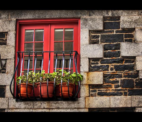 Балкон с красными окнами из ПВХ и раскладкой